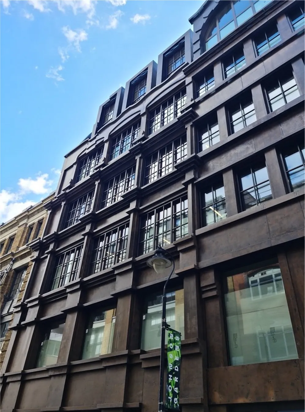 Low-angle view of a dark metal-clad facade with industrial-style glazed door and window units