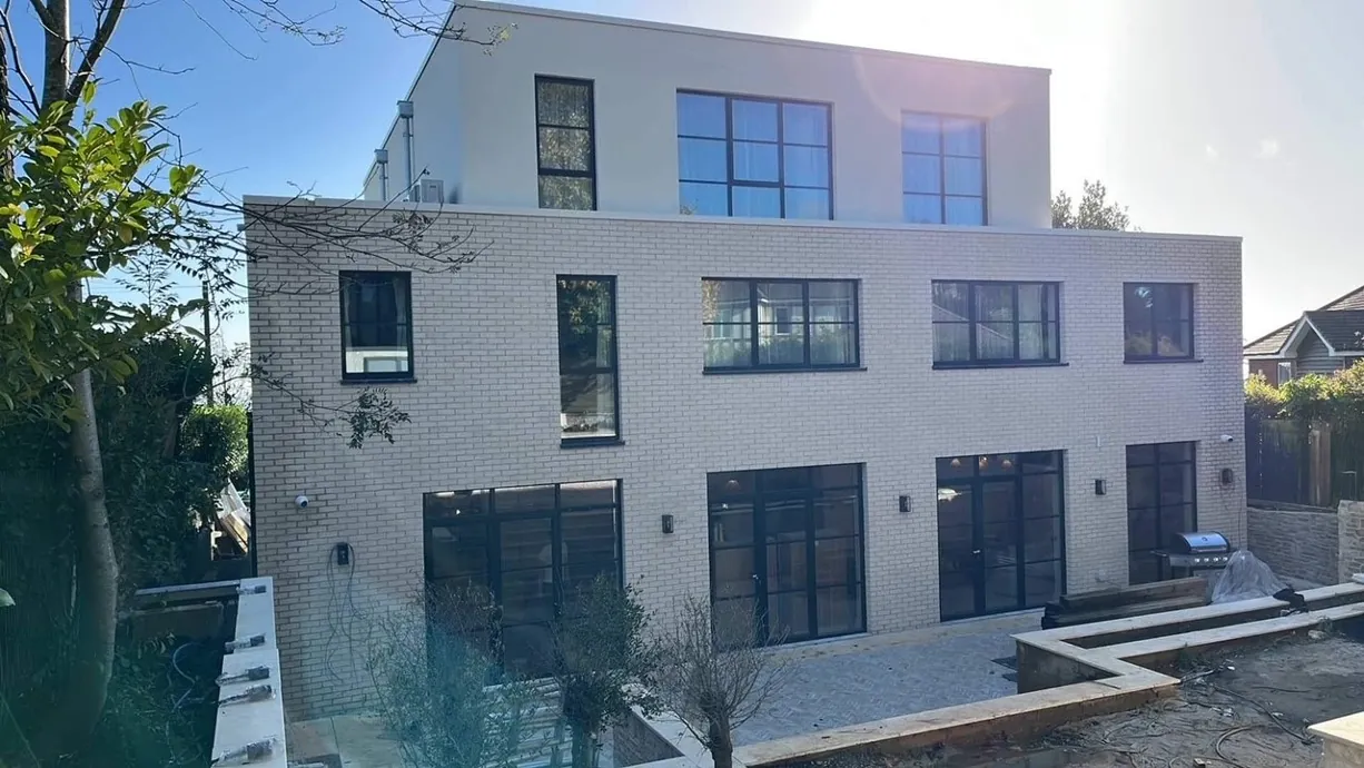 Rear extension with a large angled glazed unit following the roof pitch above a tiered garden
