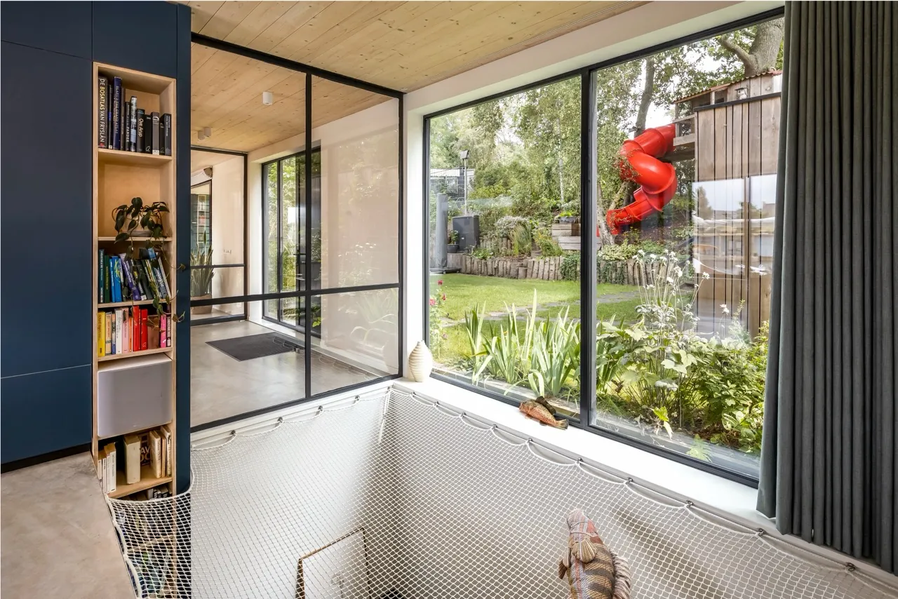 Interior with a structural glazed floor well beside a glazed garden wall